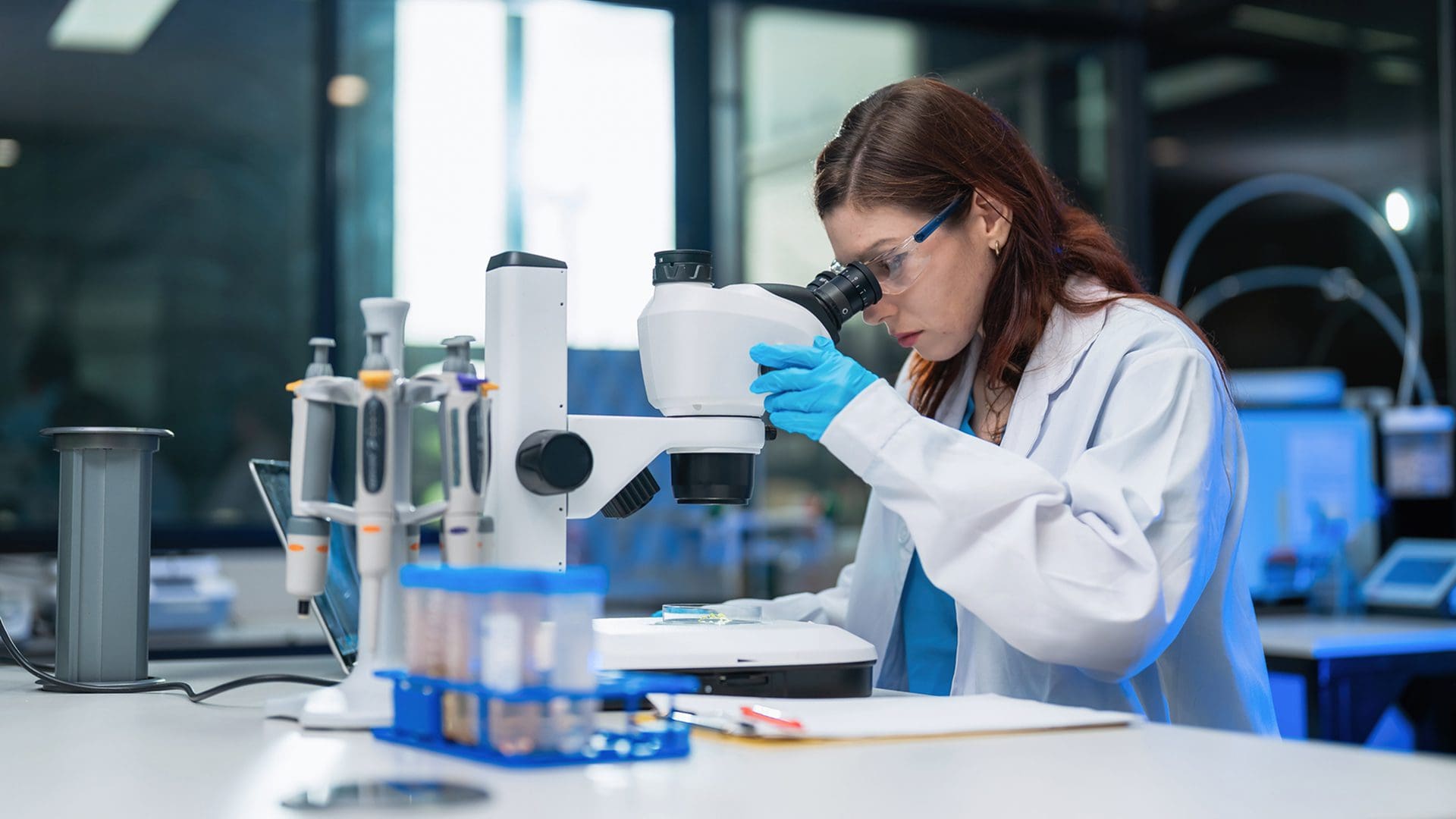 Scientist examining samples through a microscope.
